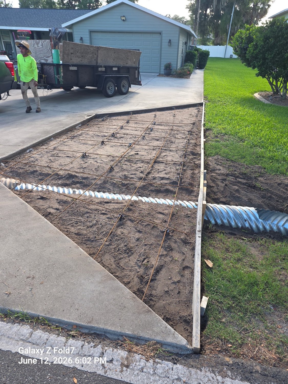 Driveway extension prepared with form boards and reinforcing steel before concrete placement