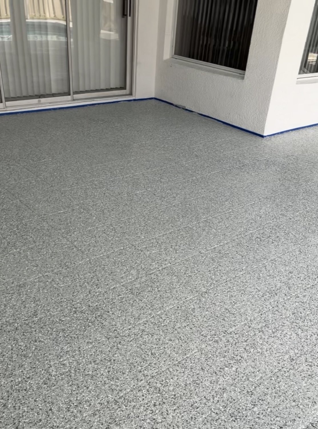 Gray decorative flake finish on a screened patio floor