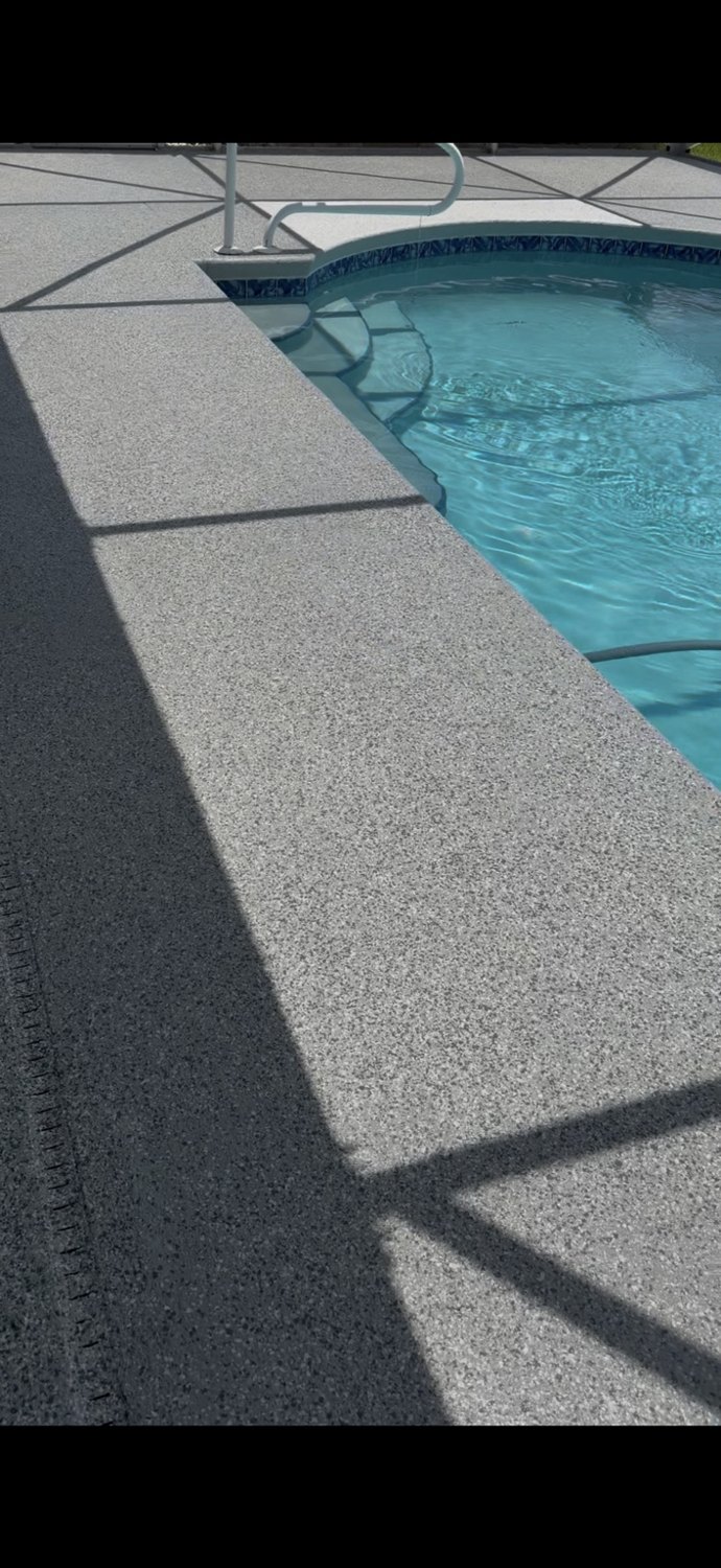 Decorative flake pool deck surface around swimming pool