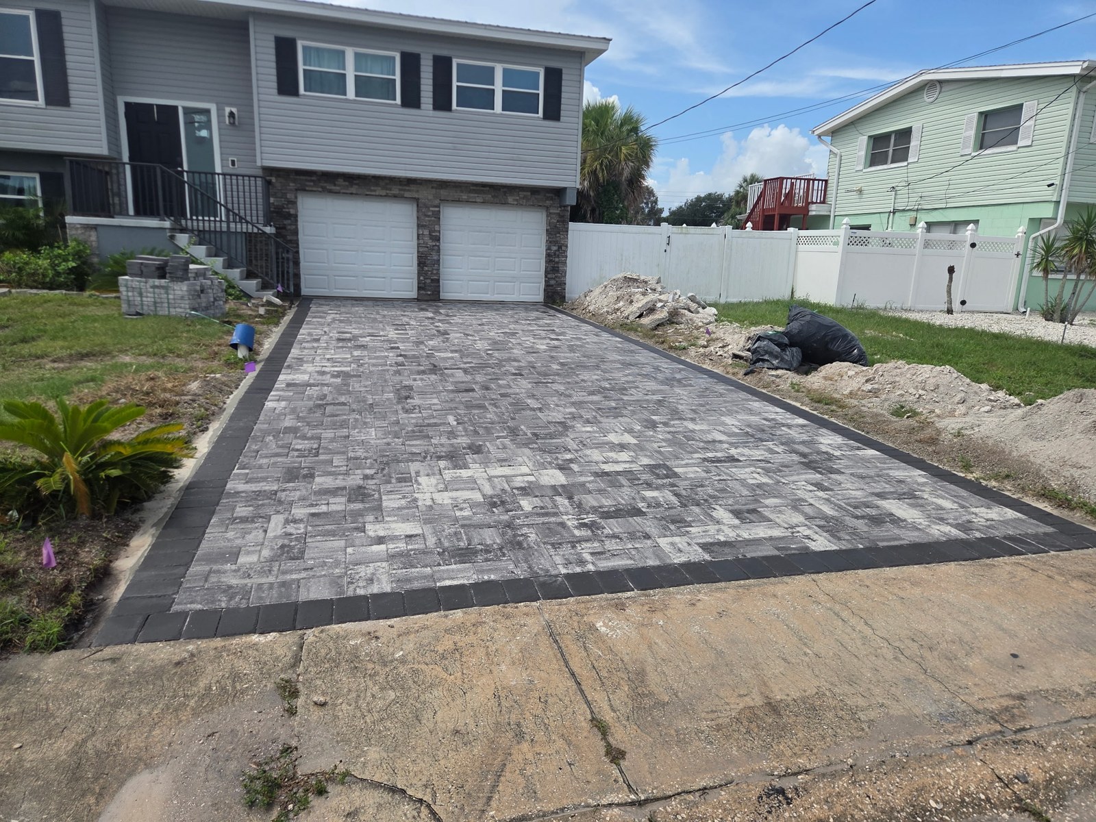 Completed gray paver driveway with charcoal border